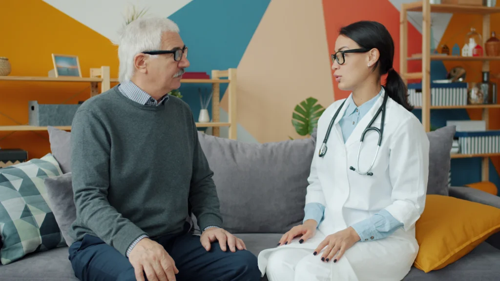 Care professional consulting with a senior man at home