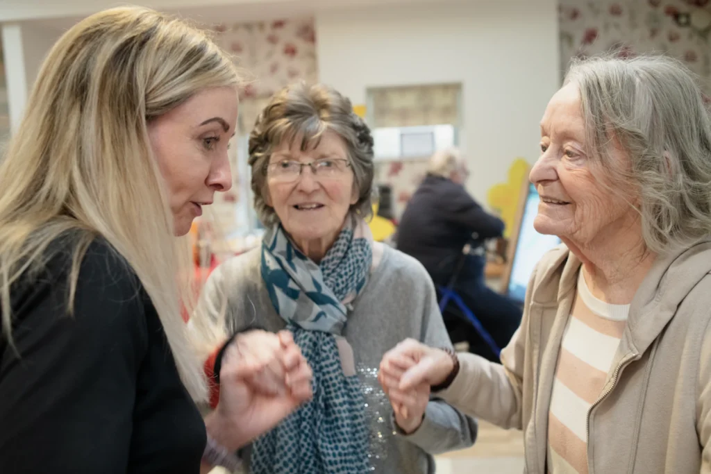 Caregiver dancing with two senior residents