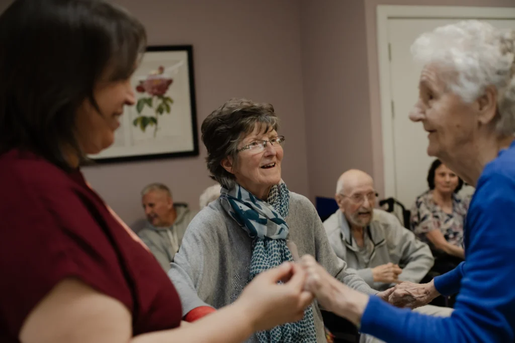 Caregiver holding hands with residents