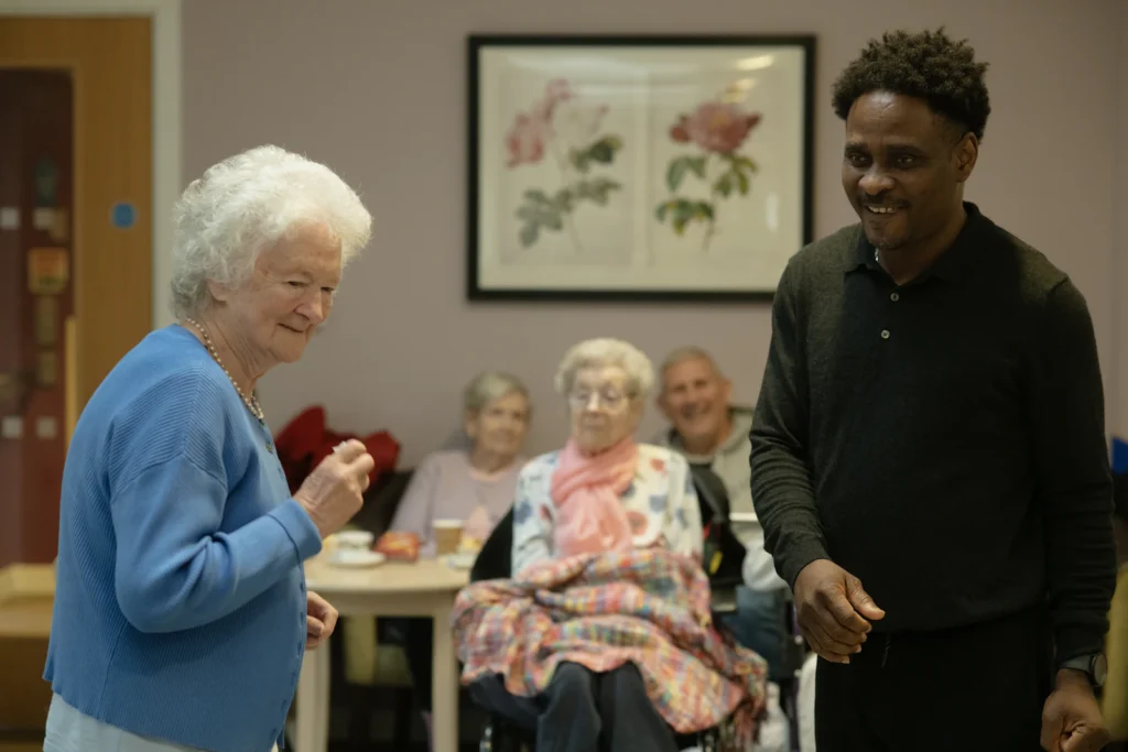 Caregiver chatting with residents in a lounge