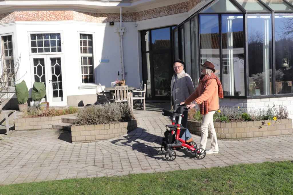 Senior couple with a rollator on a sunny patio