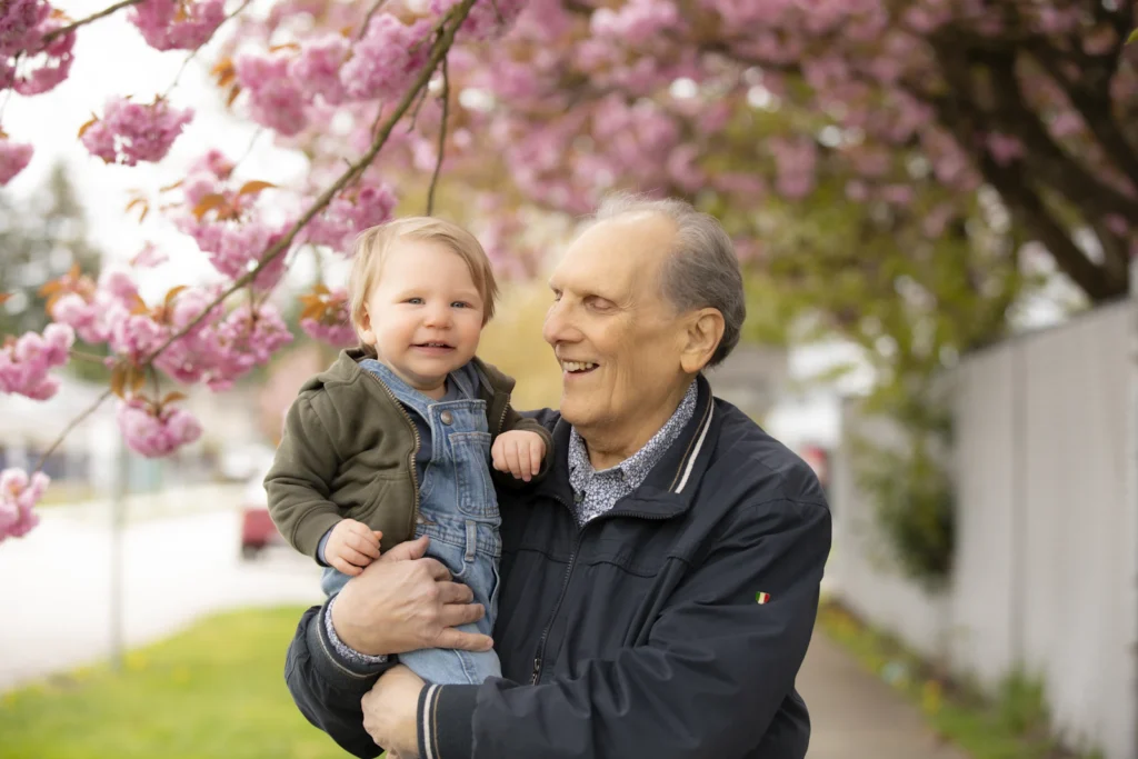 Grandfather with a baby under blossoms
