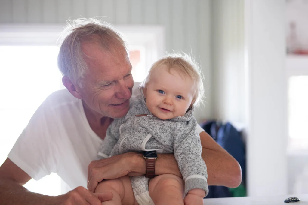 Grandfather with a baby at home