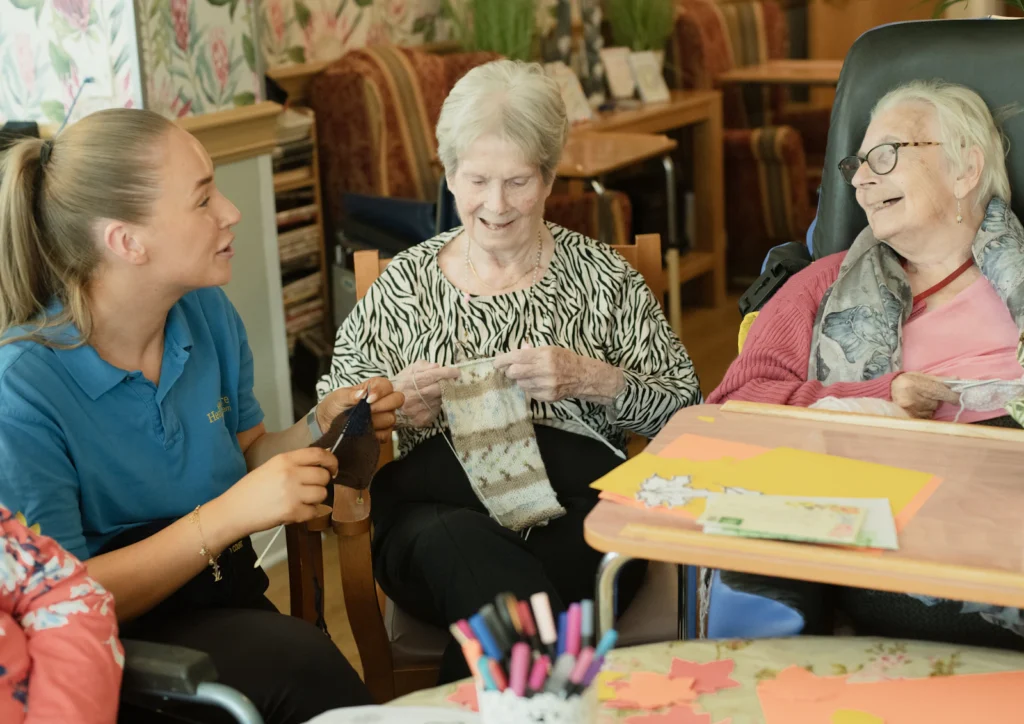 Caregiver with two senior residents doing crafts