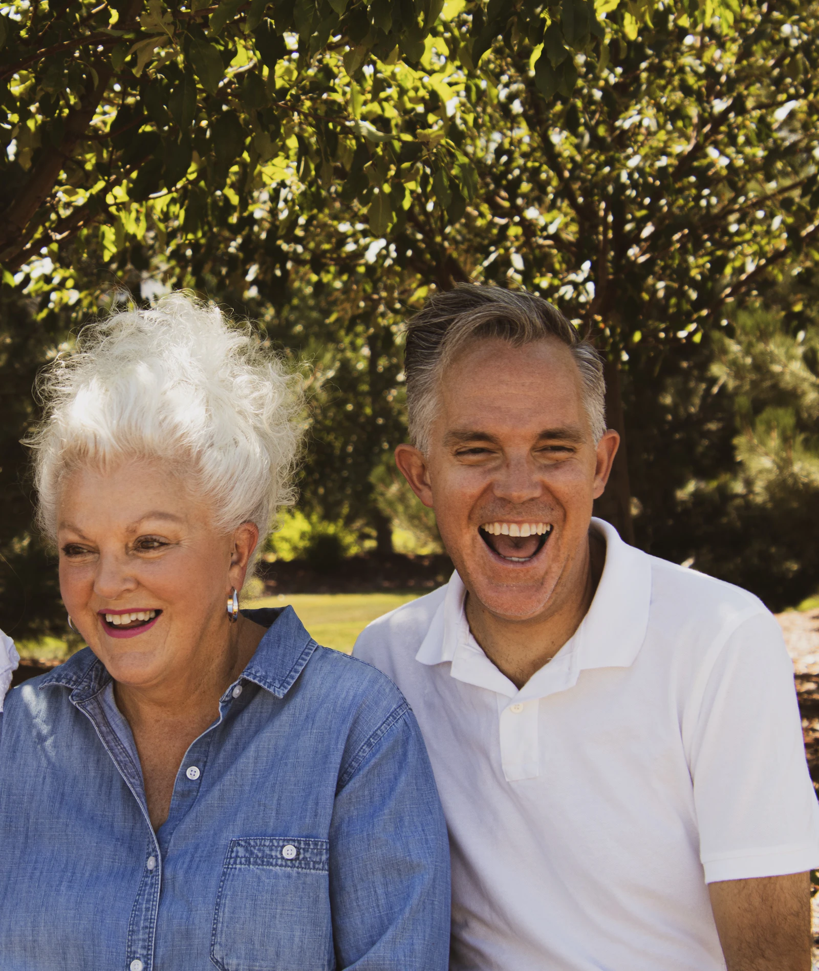 Senior mother and adult son laughing outdoors