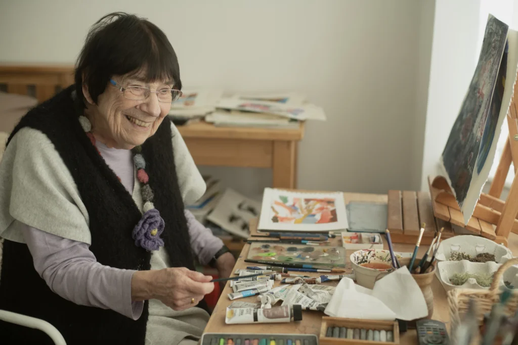 Senior woman smiling while painting