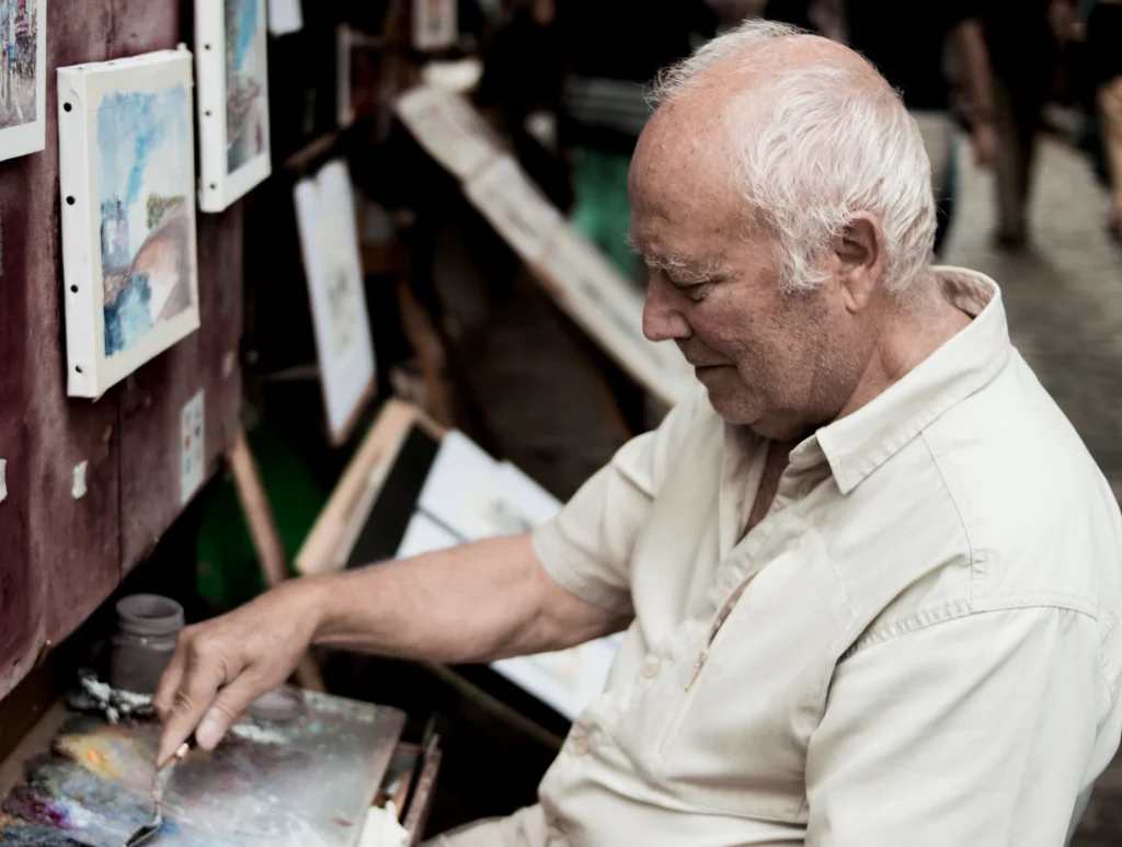 Senior man painting at a table