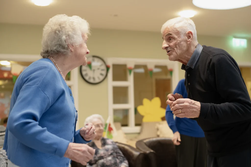 Senior residents dancing in a lounge